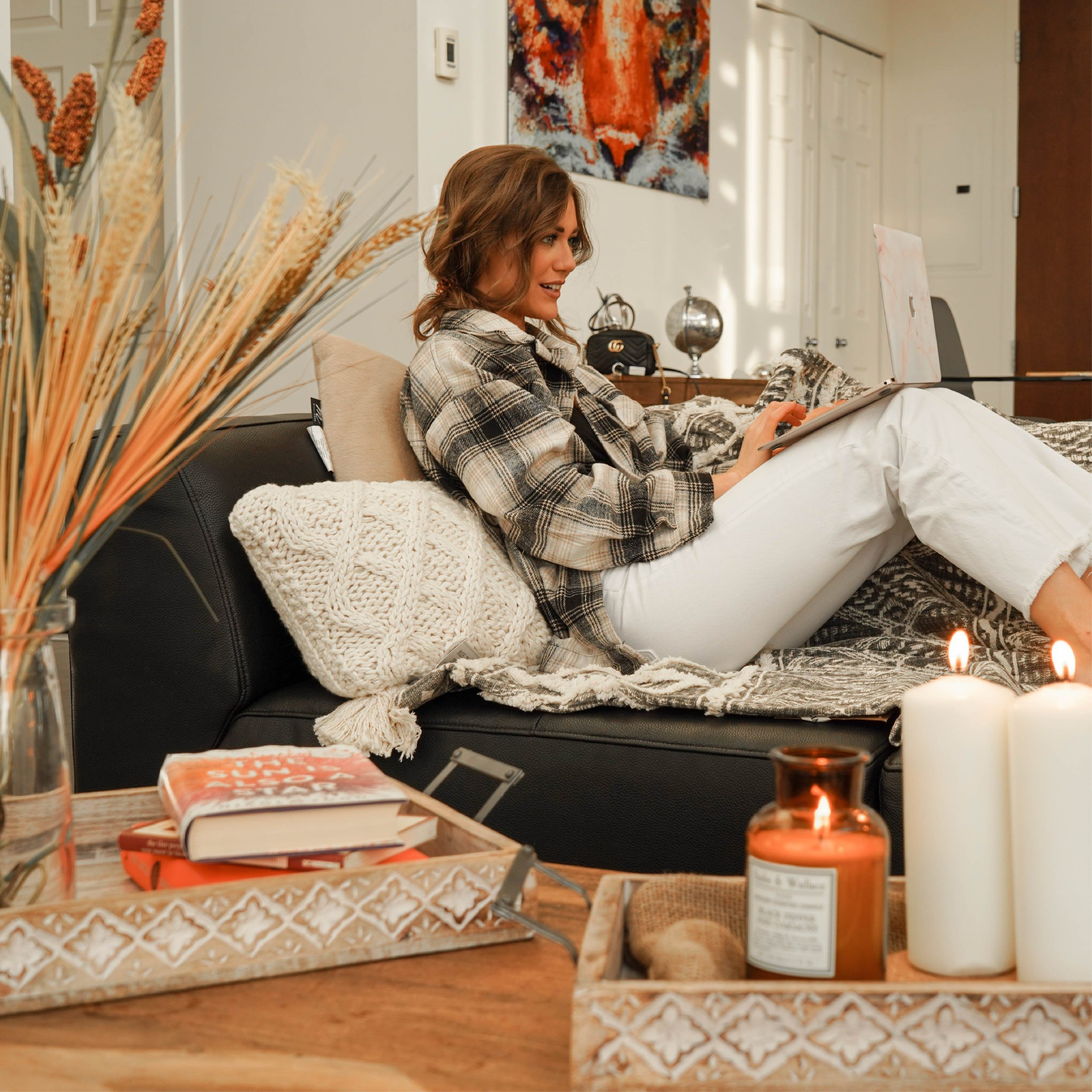 A business traveler at ease in a furnished apartment living space — laptop open