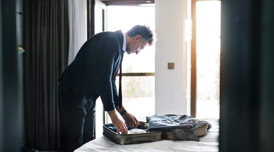 Man unpacking his belongings in a fully furnished corporate housing apartment